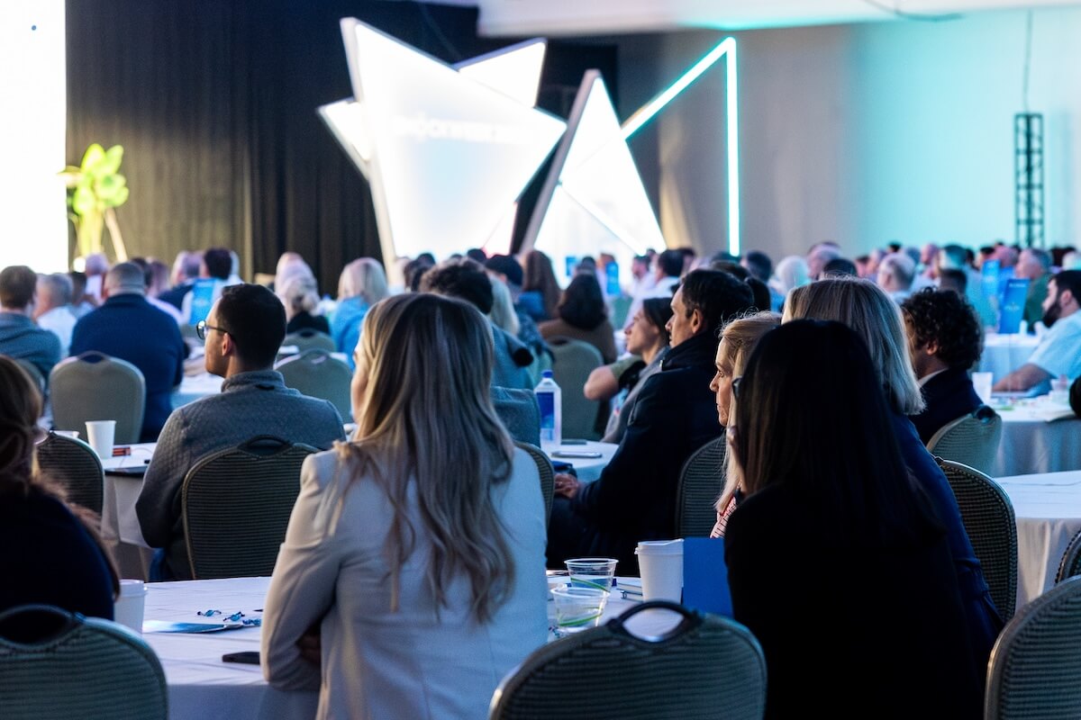 A conference room full of people looking at a stage